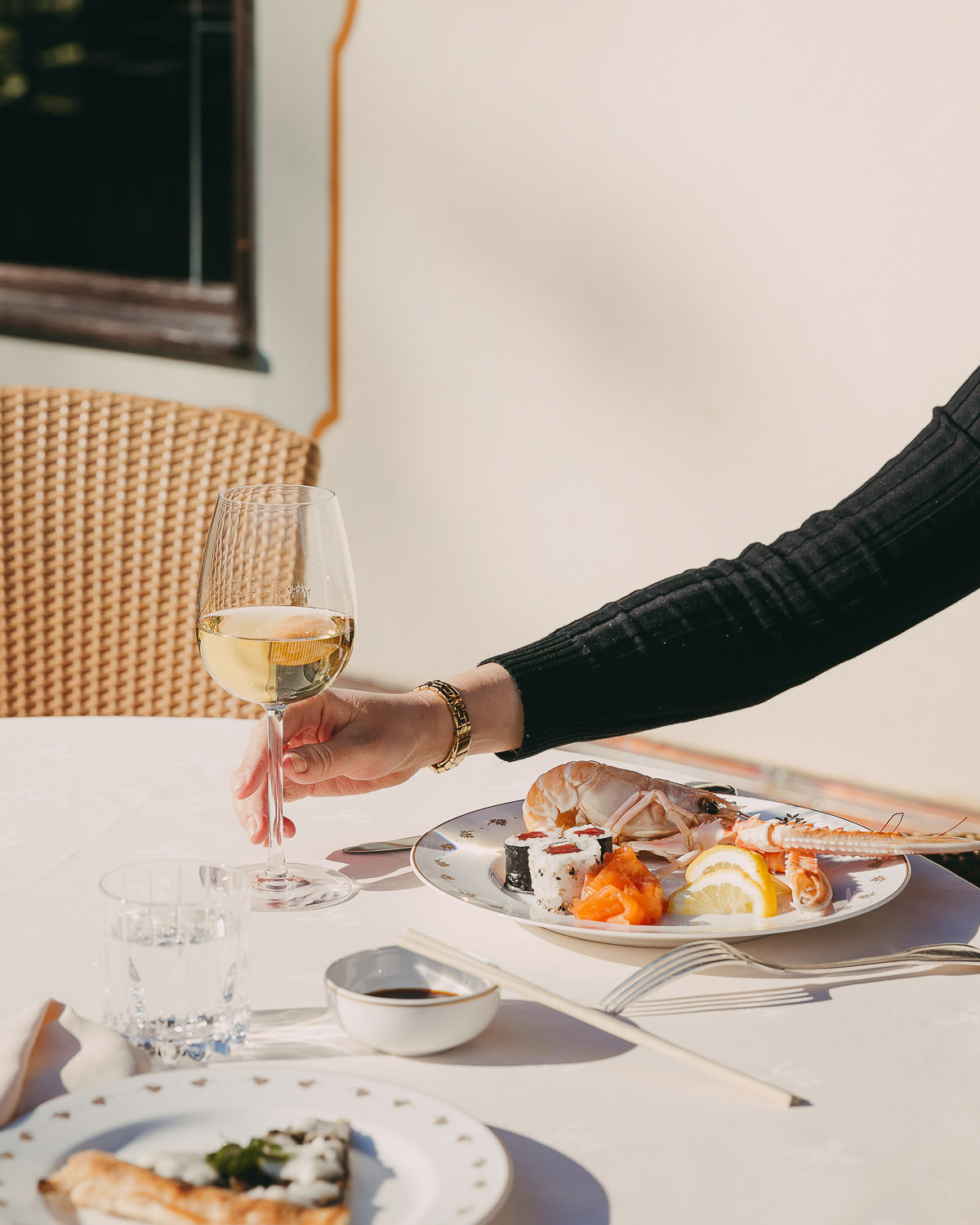 woman holding a glass of white wine and having sushis at airelles courchevel