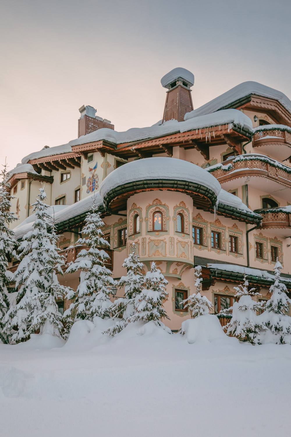Airelles Courchevel hotel covered in snow at sunrise