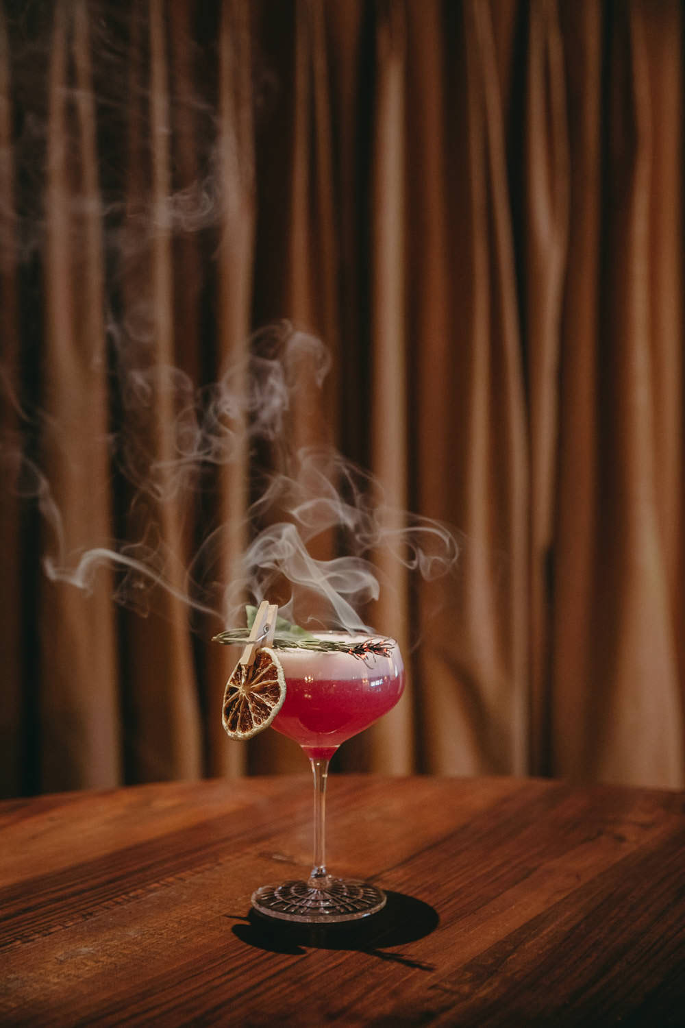 pink smoking cocktail on a wooden table at airelles courchevel