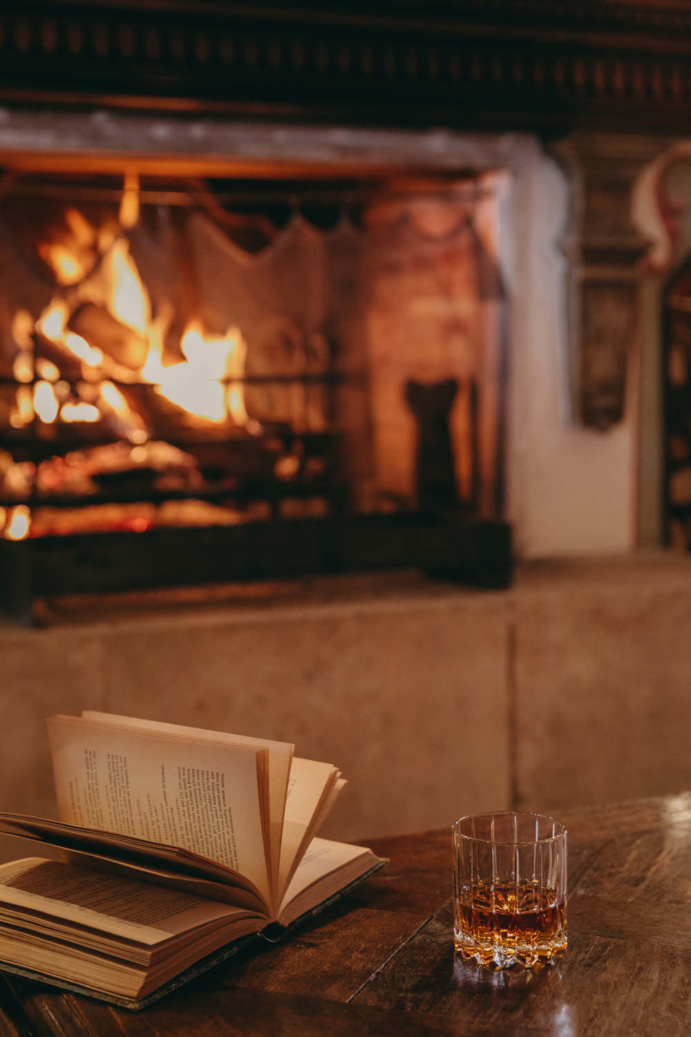an old book and a whisky by the fireplace airelles courchevel
