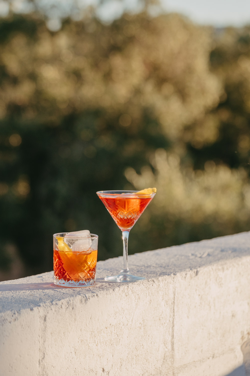 cocktails on a balcony with olive trees in the background