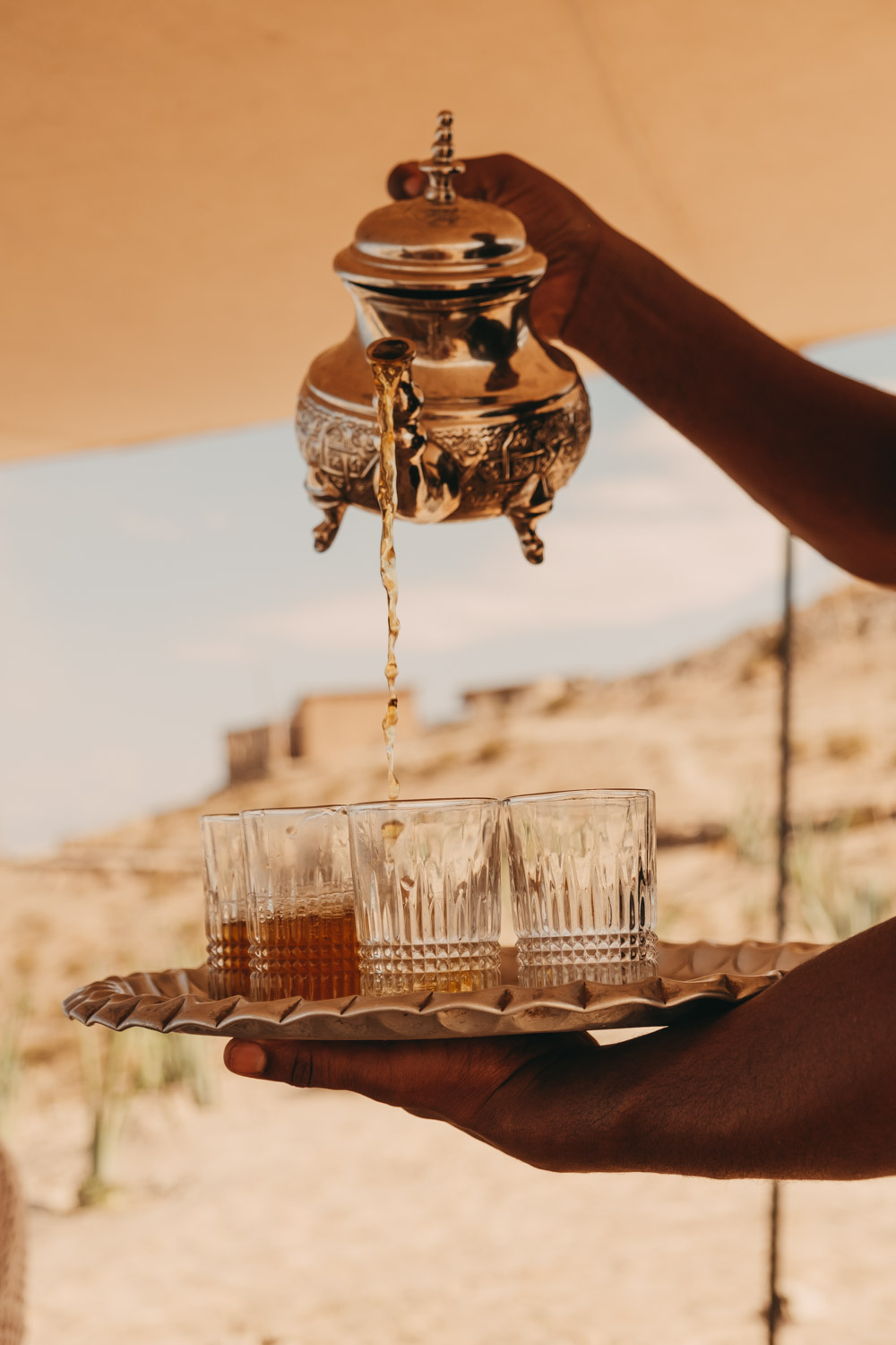 someone pouring mint tea at scarabeo camp
