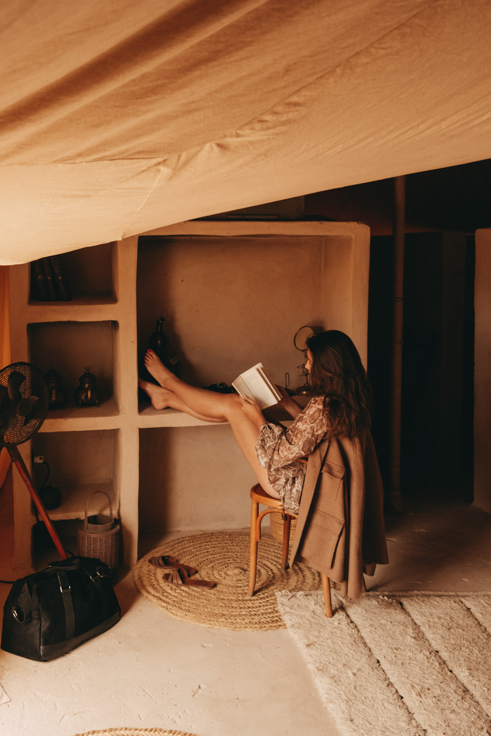 woman reading a book in a tent at scarabeo camp